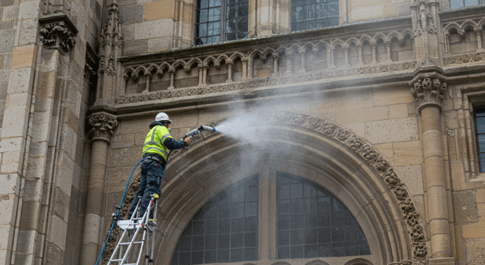 Műemlék épületek tisztítása - Szárazjég technológia alkalmazása Műemlék épületek tisztítása szárazjég technológiával - szakember dolgozik történelmi homlokzaton