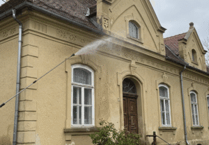 Nyári homlokzat karbantartás folyamatban nagy nyomású tisztítóval